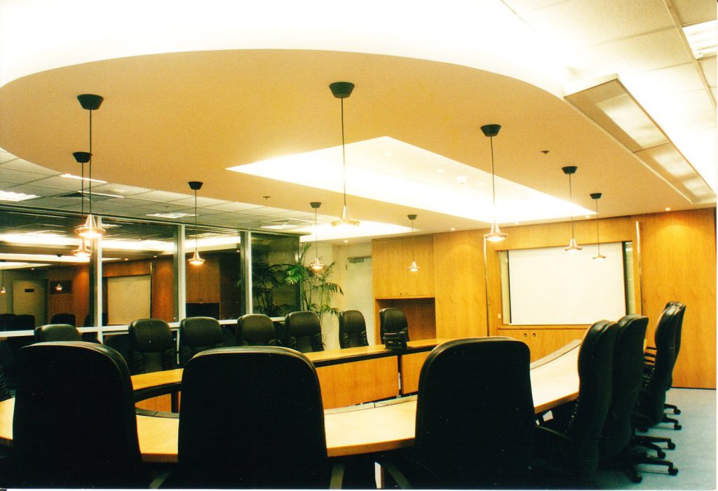 Conference room with wooden table, black chairs, and curved ceiling design