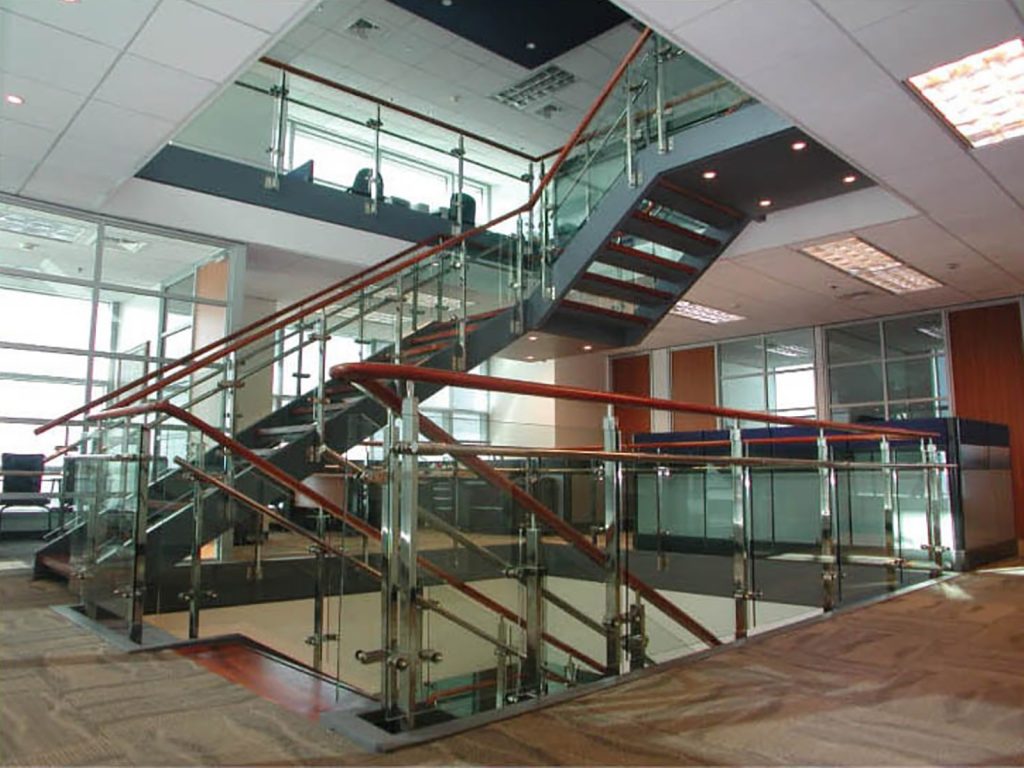 Modern internal staircase with red metal railings and frosted glass panels