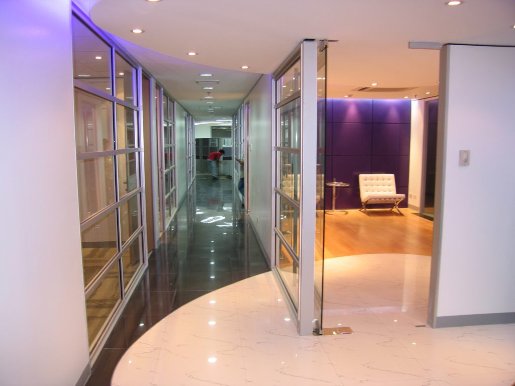 Modern corridor with glass office partitions and polished flooring