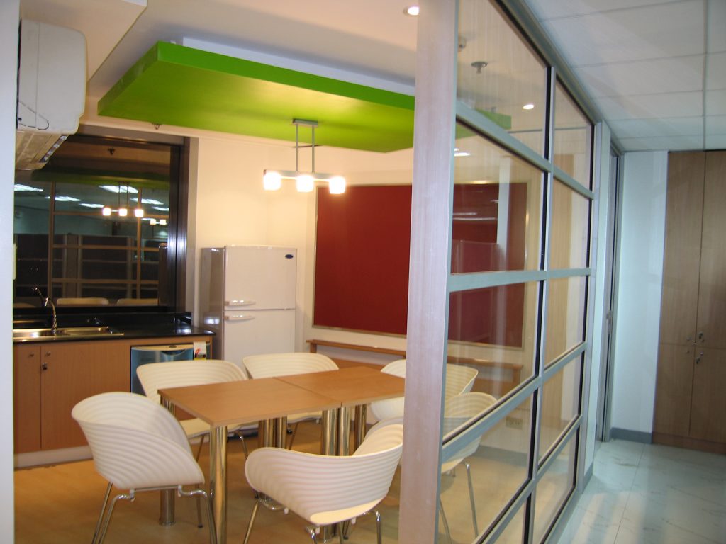 Break room with green soffit, kitchen counter, and dining table